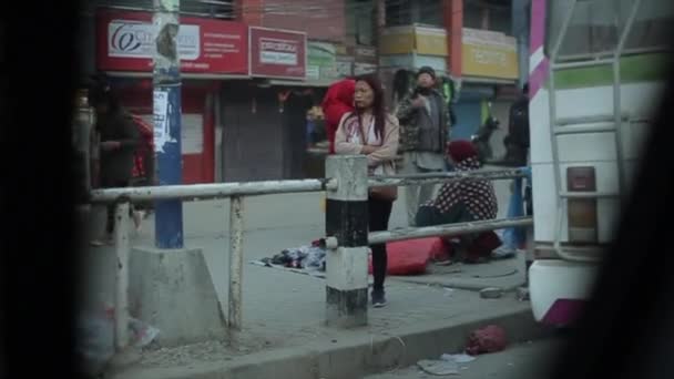 Kathmandu, Nepal - 22. November 2019: Ein Blick aus einem fahrenden Auto auf dem Bürgersteig von Nepal. Bettler, traurige, unglückliche Fußgänger. Schmutziges Pflaster. — Stockvideo