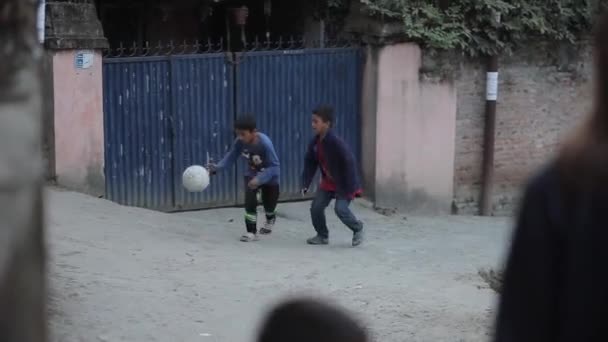 Kathmandu, Nepal - 22 november 2019: Indiase kinderen die buiten voetballen. India. Dribbelen met de bal. — Stockvideo