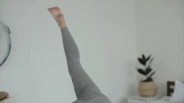 Güzel genç kız evde yoga yapıyor. Yakın plan. Kamera kızların hareketlerini takip ediyor.