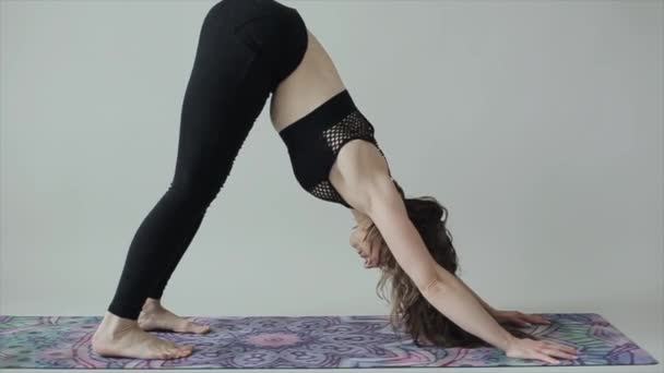 A young athletic girl practices yoga and does a headstand at home. Close-up. The camera moves from bottom to top. Quarantine covid-19 — Stock Video