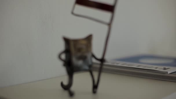 Auf dem Tisch liegt eine kreative Figur einer Kupferkatze mit einer Fahne in der Pfote. Nahaufnahme. Rahmenfokus