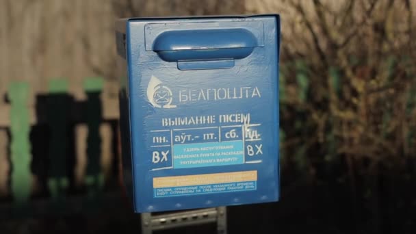 Bobruisk, Belarus - 20 April 2020: Blue mailbox that stands on the street of a Slavic village. Close-up. Blurred background — Stock Video