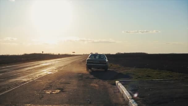 그 차는 도로에 있는 구덩이를 따라 속도를 줄이고는 다시 시골에 있는 간선도로로 돌아왔다. 뒷모습 — 비디오