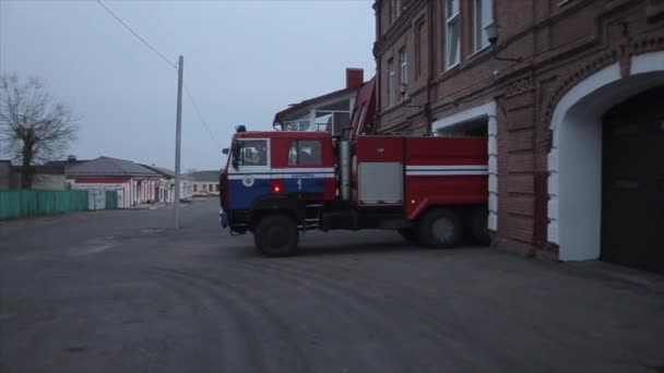 Bobruisk, Bielorrusia - 20 de abril de 2020: Un moderno camión de bomberos sale del garaje con luces intermitentes encendidas. Vista lateral. Primer plano — Vídeo de stock