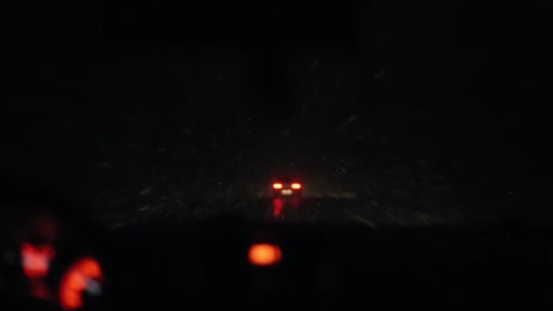Karlı bir yolda bir arabanın ön camından bak. Gösterge paneli ışıkları ve araba farlarının odaklanmış görünümü — Stok video