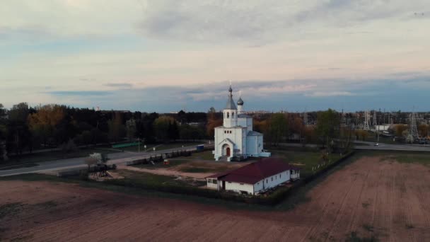 Luchtfoto van een Russisch-orthodoxe kerk op een achtergrond van stadsgezicht en een prachtige lucht met wolken — Stockvideo