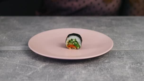 Assortiment de rouleaux de sushi sur une assiette avec différentes garnitures et avec des légumes frais et des herbes. La nourriture japonaise traditionnelle. Macro shot — Video