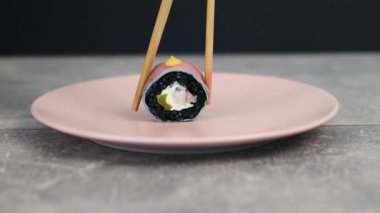 Narin dolgulu siyah pirinç ruloları pembe ve mavi soya kağıdına sarılıdır. Makro çekim