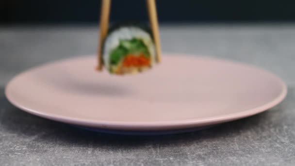 Japanese rolls with a bright filling of red fish and green vegetables on a plate. Traditional asian food. Macro shot. 4K — Stock Video