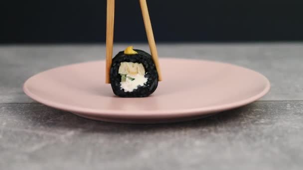 Традиційні японські рулони чорного рису, наповнені рибою та овочами. Азійська їжа. Макро стріляв. 4K — стокове відео