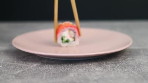 Assortiment de rouleaux de sushi sur une assiette avec différentes garnitures et avec des légumes frais et des herbes. La nourriture japonaise traditionnelle. Macro shot — Video