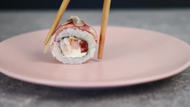 Sushi tekercsek vörös hallal és friss zöldségekkel egy tányéron. Hagyományos japán menü. Makró lövés. Változtasd meg a kamera irányát. 4K — Stock videók