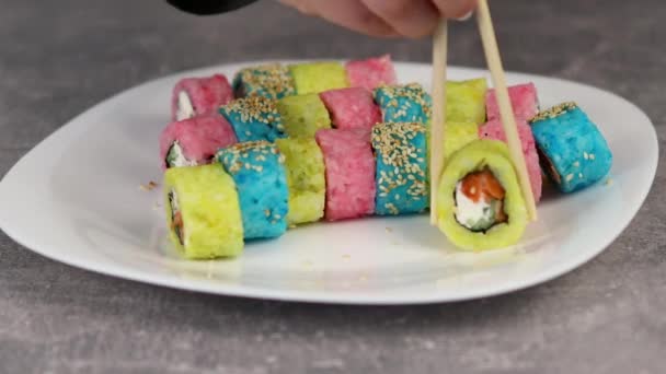 Den ursprungliga beredningen av traditionell japansk sushi. Blått och rosa ris rullar fyllda med fisk och skaldjur och färska grönsaker. Makroskott — Stockvideo