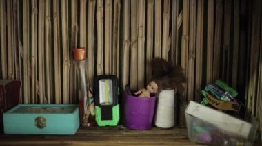 Katmandu, Nepal - 27 Kasım 2019: Farklı nesnelerle dolu bakire raf ve bambudan dekoratif bir duvarın arka planında bir bebek. Yakın plan.