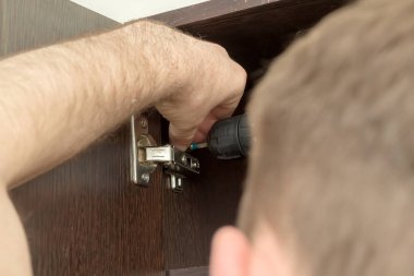 Adjusting, fixing cabinet door hinge clipart