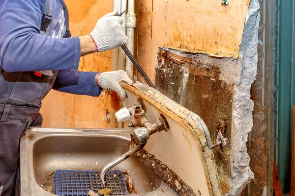 Handen loodgieterswerk dicht met een metalen kop — Stockfoto