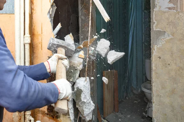 Il martello costruttore rompe vecchie partizioni nell'appartamento Foto Stock