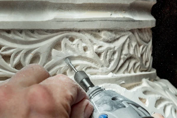 Руки, вырезающие орнамент на штукатурке — стоковое фото