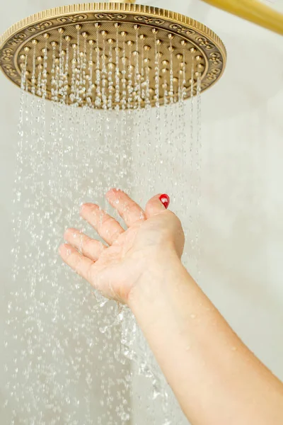 Famale main vérifier la température de l'eau dans la douche  . — Photo