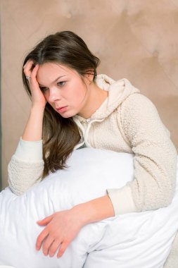 Yatakta baş ağrısı çeken güzel bir kadın.