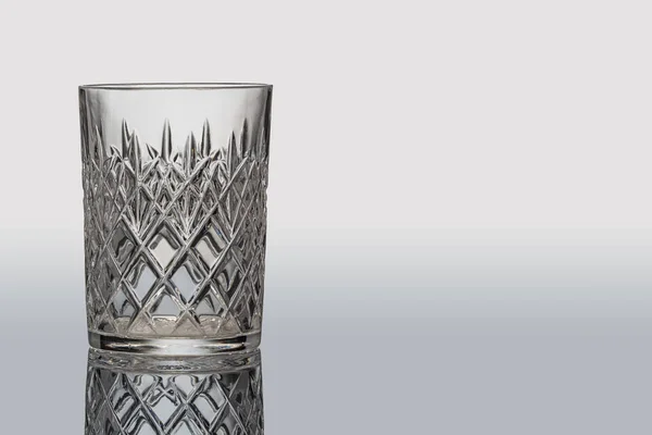 Empty crystal glass on a gray background — 图库照片