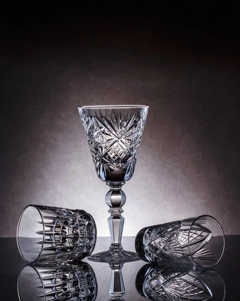 Empty crystal glasses of various sizes on a gray background — Stok fotoğraf