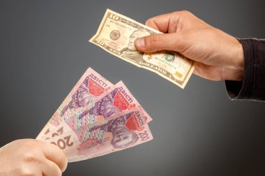 Hands exchange hryvnia and dollars