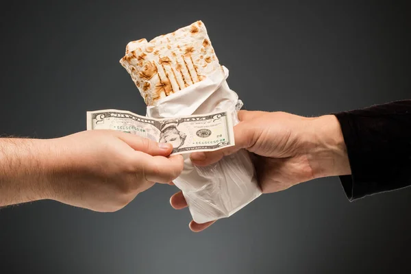 Hands exchange shawarma and dollars — Stock Photo, Image