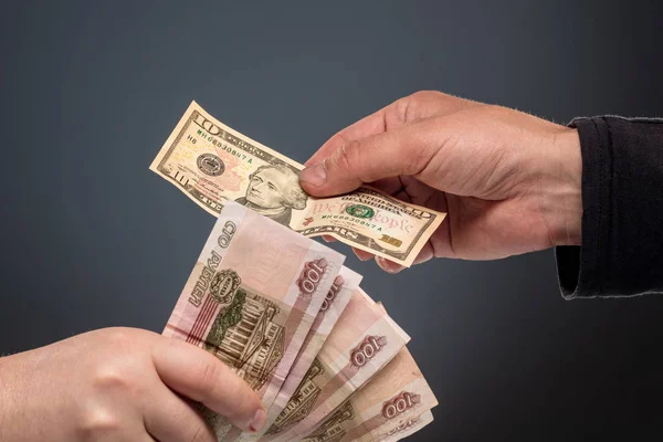 Le mani scambiano rubli e dollari Foto Stock Royalty Free