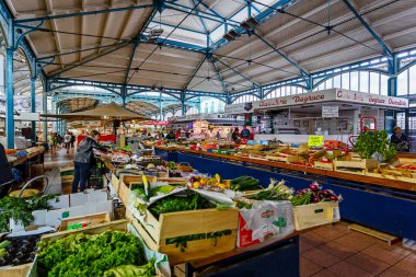 Market  with various fruits and vegetables, sellers and shoppers