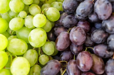 Kırmızı ve beyaz üzümler yığılmış.