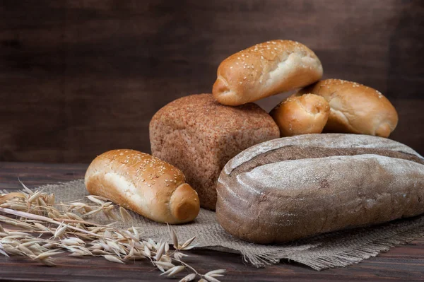 木製の背景上のパンの品揃え ロイヤリティフリーのストック画像