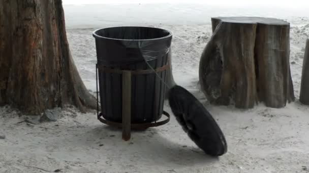 Ветер бьет одинокий мусорный бак, висящий на берегу моря — стоковое видео