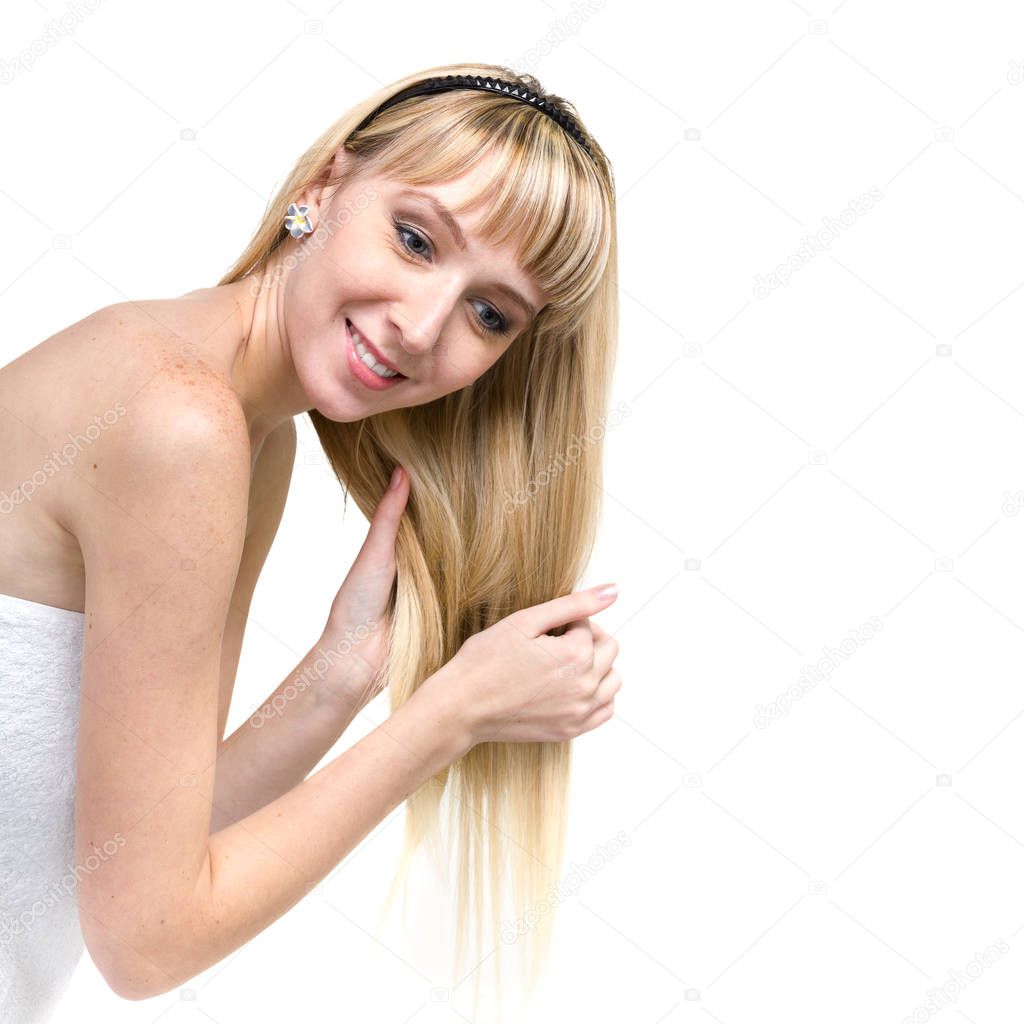 Cheerful blonde combs hair, it is isolated on white.