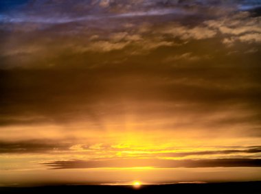Güneşin doğuşunda fantastik kara bulutlar