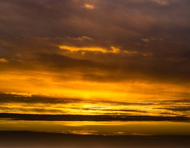 Güneşin doğuşunda fantastik kara bulutlar