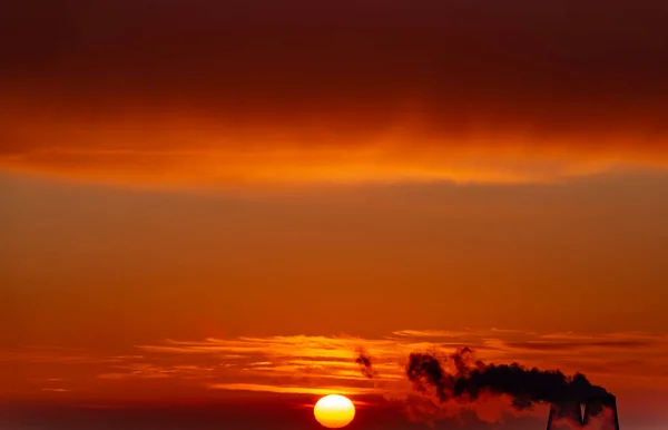 日の出に火力発電所の管から煙 — ストック写真