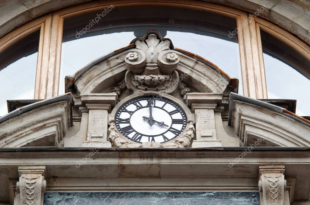 Clock on the facade of an old house.