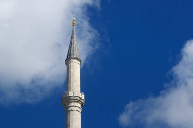 Mavi gökyüzüne karşı caminin minaresi.