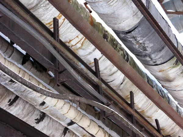 Old pipes and cables on the estocade of an industrial enterprise. — Stock Photo, Image