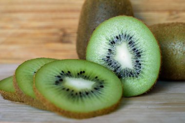 Ahşap dokunun arka planında taze kivi dilimleri..