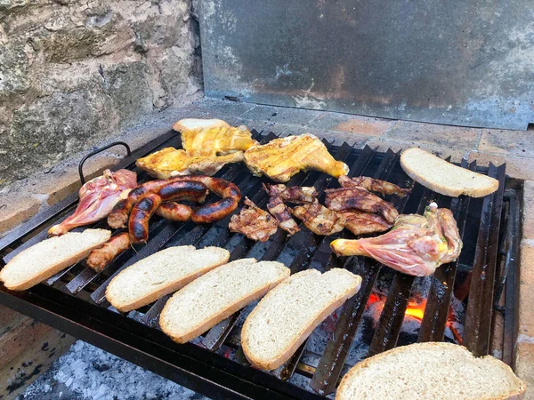 meat and bread on the barbecue at friends house during holidays at mallorca island