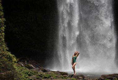 Genç sarışın kadın Bali 'de şelaleyi keşfediyor, Asya' da tatil yapıyor.