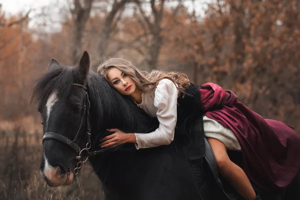 馬の屋外で美しい若い女性 ブルネットの若い女の子は黒い馬に乗る — ストック写真