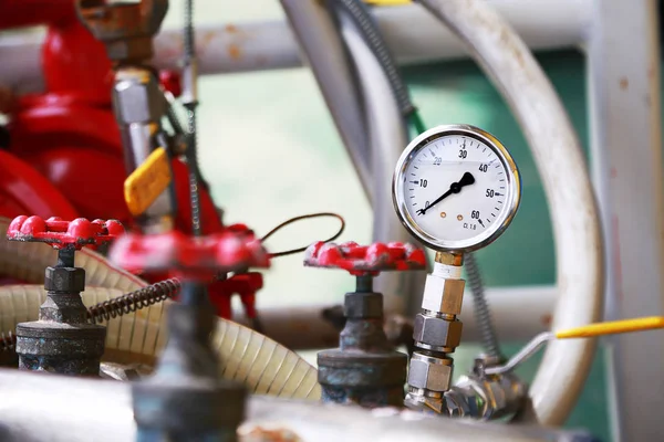 Medidor de presión mediante la medición de la presión en el proceso de producción. Operador o trabajador que supervisa el proceso de petróleo y gas por el medidor para el registro y análisis rutinarios proceso de producción de petróleo y gas . — Foto de Stock