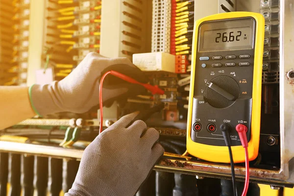 Elektrisk terminal i samledåse og service af tekniker. Elektrisk enhed installere i kontrolpanelet til støtte program og kontrol funktion ved PLC. rutinemæssige besøg check udstyr af tekniker . - Stock-foto