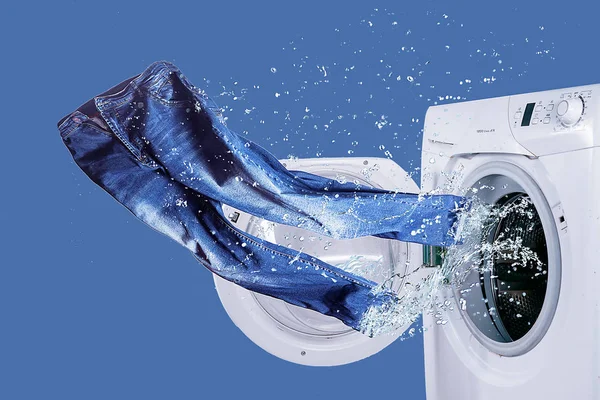 Washer and freshly laundered jeans — Stock Photo, Image