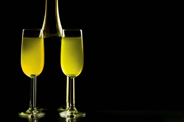 Szemüveg és üveg pezsgőt elszigetelt a fekete háttér — Stock Fotó
