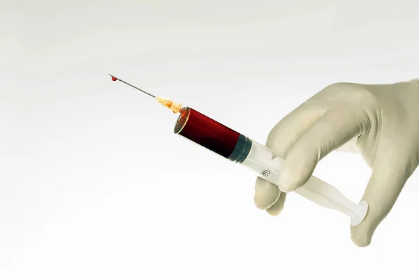 Ruku v bílé rukavici s injekční stříkačkou — Stock fotografie