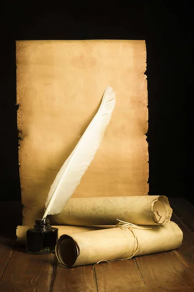 Bläckhorn med en ljus penna, rullar av papyrus på bakgrunden av gamla papper utvecklats Stockfoto